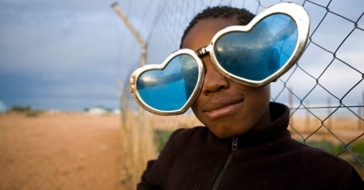 Eine Flüchtlingskind mit selbstgebastelter Herzbrille im Camp Osire, Angola. Eine Flüchtlingskind mit selbstgebastelter Herzbrille im Camp Osire, Angola._©UNHCR / Brandon Bannon